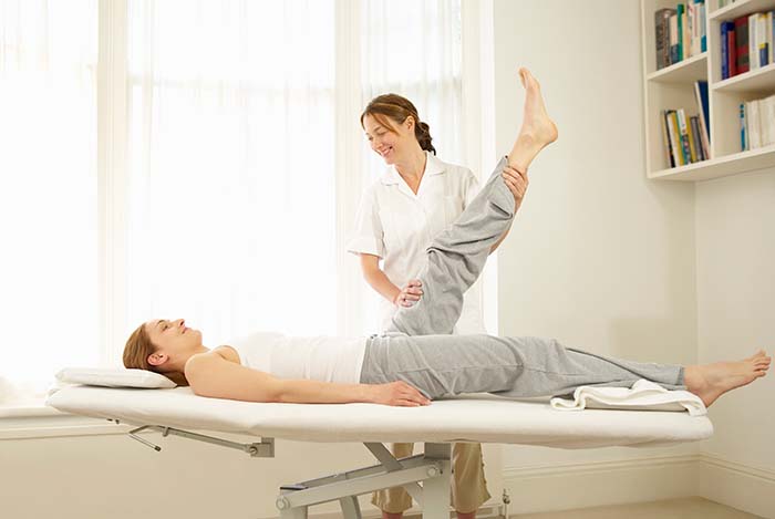 Mujer realizando recuperación de la rodilla en la consulta de una fisioterapéuta