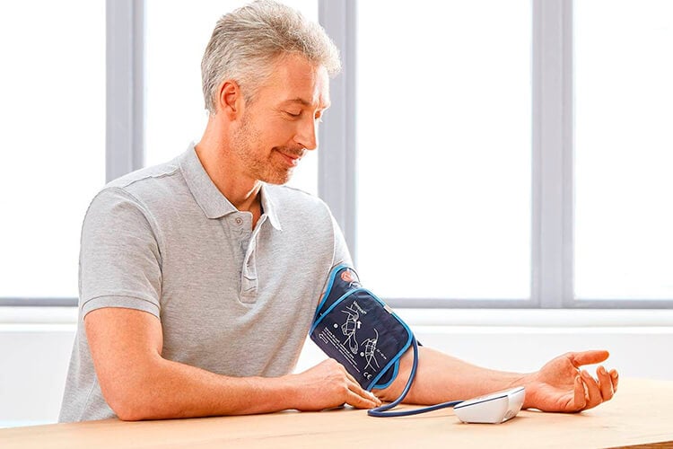 Hombre midiéndose la presión arterial con veroval