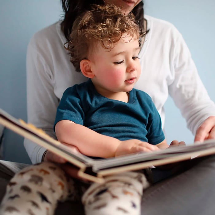 Niño de 3-5 años leyendo con su madre un libro infantil