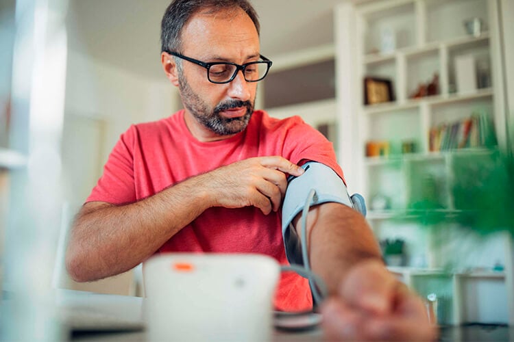 Hombre se controla la tensión arterial con su tensiómetro de brazo veroval