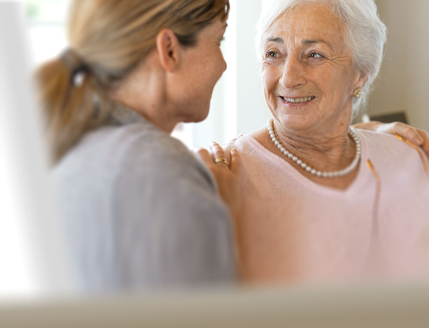 Seniorin wird von Tochter in Arm genommen
