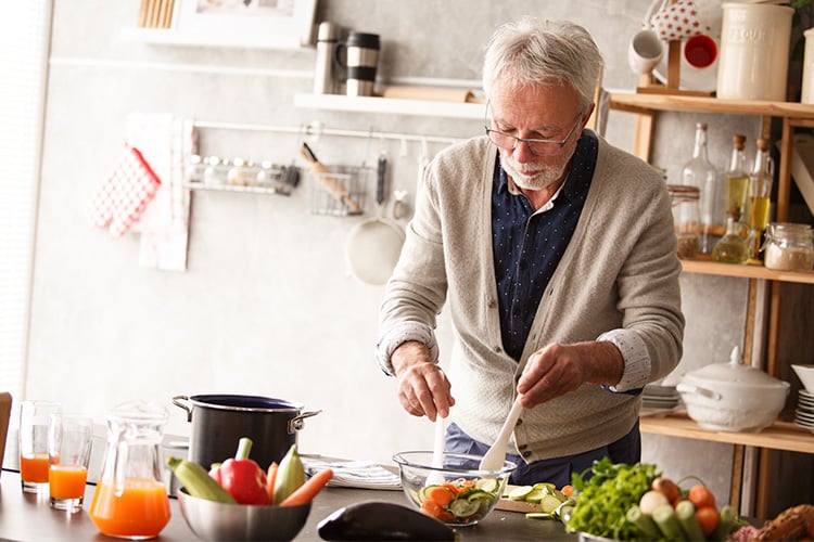 Hombre mayor cocinando sano para reducir los efectos de la vejiga inflamada