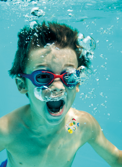 Niño jugando debajo del agua con una Tirita en el hombro - HARTMANN Direct